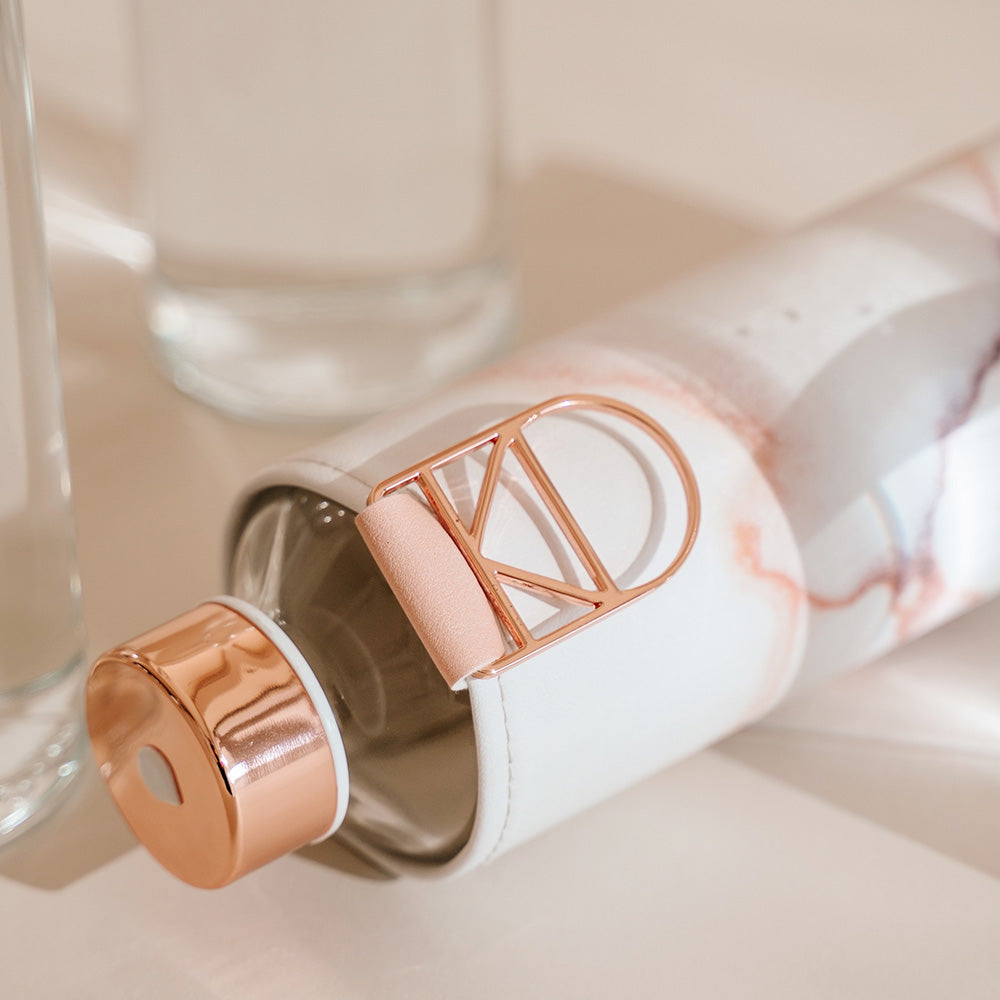glazen fles met rose gouden accenten en lavasteen hoes liggens