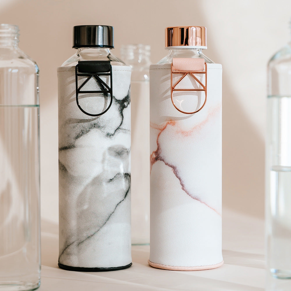 glazen fles met rose gouden accenten en lavasteen hoes met zwarte fles ernaast