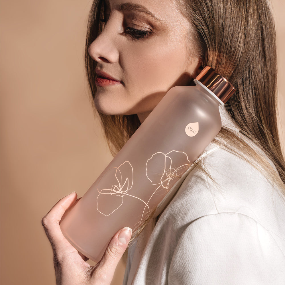 glazen fles licht roze melkglas met bloemopdruk en vrouw